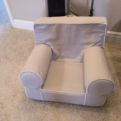 Pottery Barn Kids Anywhere Chair in a light gray fabric with white piping, showing light wear.