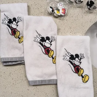 Collection of Mickey Mouse bathroom accessories, including three embroidered white hand towels, a set of ceramic drawer knobs, and two...