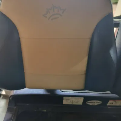 Two-tone tan and navy blue vinyl golf cart seat back featuring an embossed crown logo.