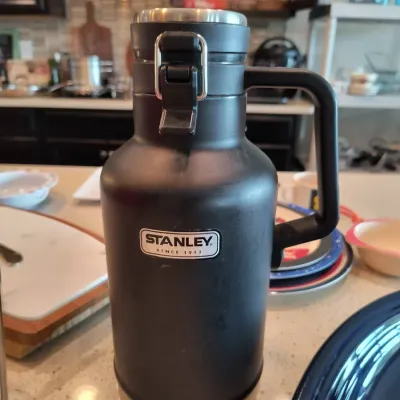 Stanley Classic vacuum insulated growler in matte black, featuring a heavy-duty handle and a secure latching lid.