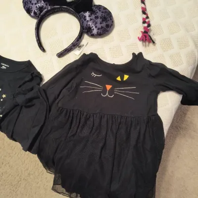 Carter's black cat-themed toddler dress with a tulle skirt, paired with a purple and black Haunted Mansion Minnie Mouse ear headband.