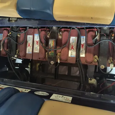 Set of six Trojan Motive deep-cycle batteries installed in a golf cart, showing wiring and connections.