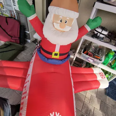 Inflatable Christmas yard decoration featuring Santa Claus piloting a red airplane, in gently used condition.