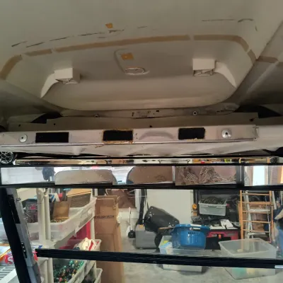 Interior view of a golf cart showing a multi-panel rearview mirror, overhead console, and speakers.