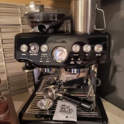 Breville Barista Express espresso machine in black sesame finish, complete with portafilter, stainless steel frothing pitcher, and...