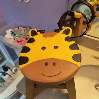 Hand-painted wooden children's step stool featuring a smiling giraffe face design.