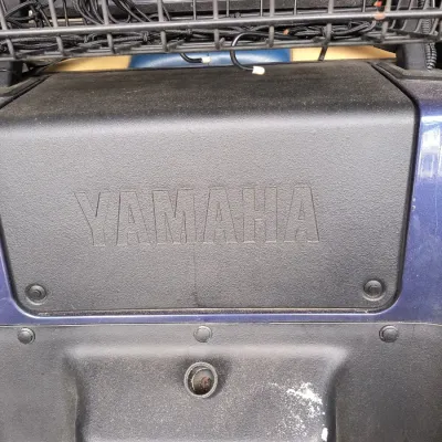 Yamaha golf cart dashboard panel showing the embossed brand logo and a wire storage basket above.