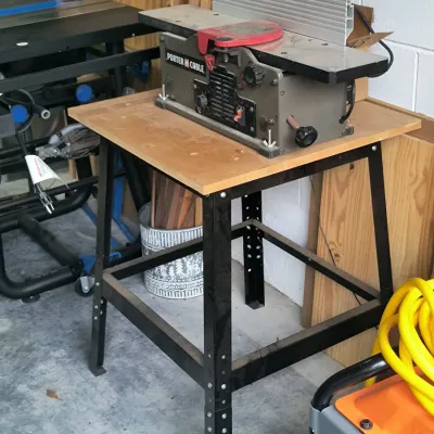 Porter-Cable benchtop jointer mounted on a black metal utility stand with a wooden top.