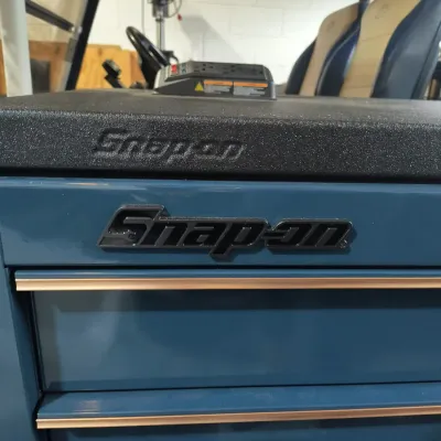 Snap-on rolling tool chest in a teal blue finish with black trim and a textured black top work surface.
