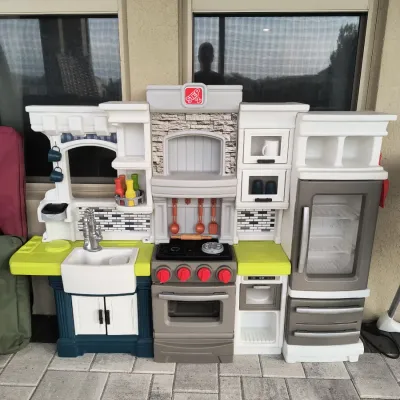 Step2 plastic play kitchen set featuring a sink, stove, oven, refrigerator, and various molded-in details and accessories.