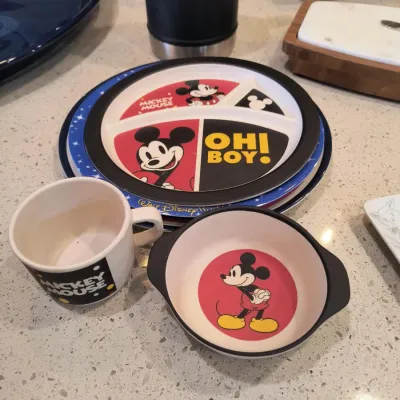 Vintage Mickey Mouse children's melamine dinnerware set, including a divided plate, bowl, and mug featuring classic character graphics.