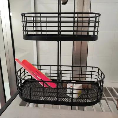 Two-tier black wire storage caddy with a wooden handle, containing a pink hair straightener and a small white adapter.
