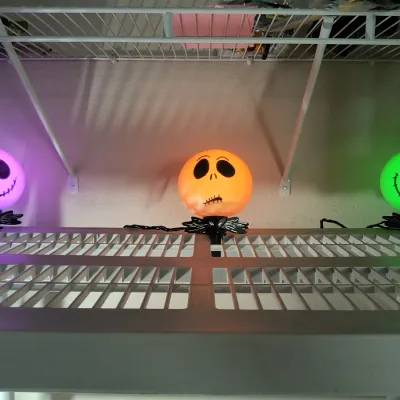 Three Disney's The Nightmare Before Christmas Jack Skellington light-up pathway markers, glowing in purple, orange, and green.