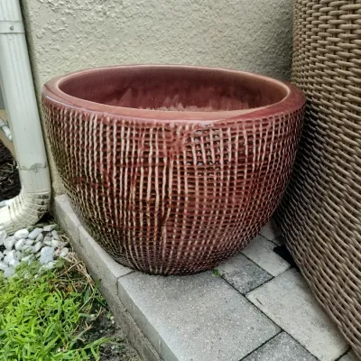 Large ceramic planter with a textured, woven-look exterior and a reddish-brown glaze.