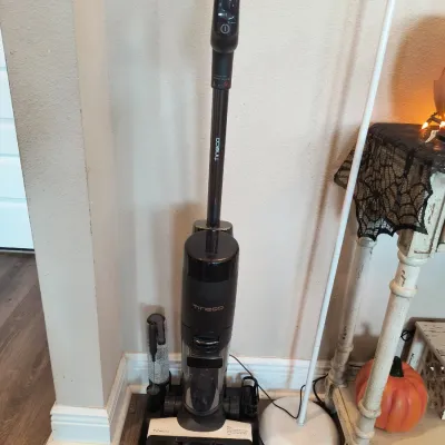 Tineco cordless wet-dry vacuum cleaner and hard floor washer, shown on its charging dock with accessories.