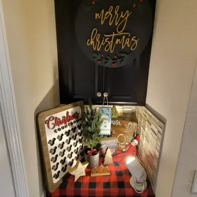 Assorted Christmas decorations, including a round "Merry Christmas" sign, a Mickey Mouse-themed countdown board, a small...