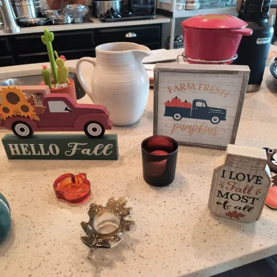Collection of autumn-themed home decor, including a "Hello Fall" truck sign, a "Farm Fresh Pumpkins" framed sign, a...