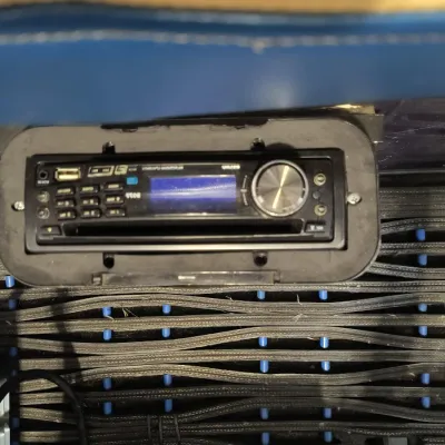 Boss Audio Systems marine-grade single-DIN receiver with USB port and CD player, mounted in a protective housing.