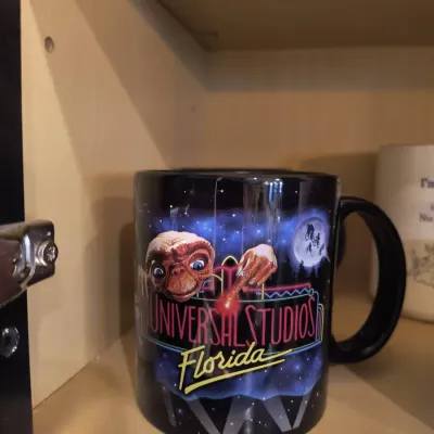 Vintage Universal Studios Florida black ceramic mug featuring E.T. the Extra-Terrestrial, in good used condition.