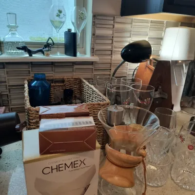Chemex classic series pour-over glass coffeemaker with wood collar and leather tie, shown alongside a box of Chemex bonded filters and...