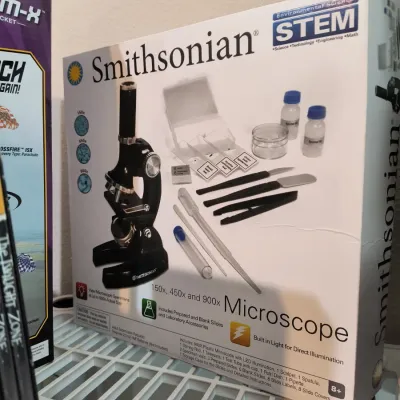 Smithsonian STEM Microscope kit in its original box, featuring 150x, 450x, and 900x magnification with prepared and blank slides.