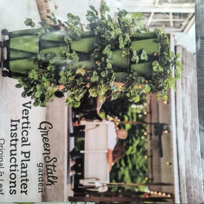 GreenStalk Garden Vertical Planter instruction manual for Original & Leaf models, enclosed in a protective plastic sleeve.