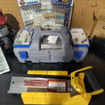 Dremel rotary tool kit with a 220-piece Mega Accessory Kit, shown alongside a Portland Saw miter box with saw.