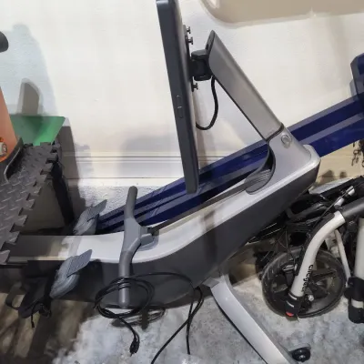 Hydrow smart rowing machine with a large touchscreen display, featuring a sleek grey and silver frame.
