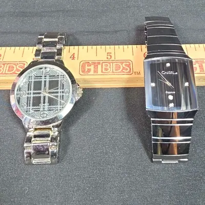 One Round Silver Watch with Plaid Background, and Chisel Rectangle Silver Watch with Clear Accents.