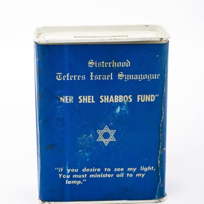 A TIN CHARITY CONTAINER COLLECTING FUNDS FOR THE TEFERRES ISRAEL SYNAGOGUE.