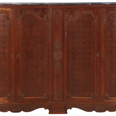 A FOUR DOOR CARVED CABINET IN THE REGENCE STYLE HAVING A MARBLE TOP AND MIRRORED BAR COMPARTMENT