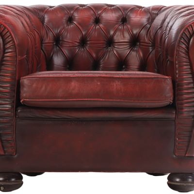 A STYLIZED RED LEATHER CHESTERFIELD CLUB CHAIR WITH BUTTON BACK UPHOLSTERY CIRCA 1950.