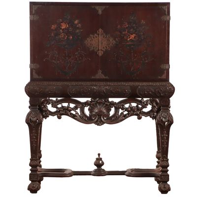 Sale Photo Thumbnail #244: CARVED WALNUT CABINET C 1920 HAVING TWO PULL OUT TRAYS. THE CASE HAVING FLORAL PAINTINGS AND BRASS