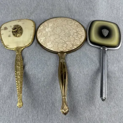 Collection of Three Vintage Hand Mirrors with Ornate and Modernist Designs