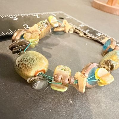 Premier Designs Island Girl Bracelet, featuring a multi-strand design with green and blue ceramic or glass beads and shell accents
