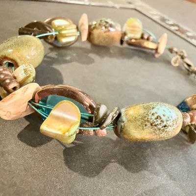 Premier Designs Island Girl Bracelet, featuring a multi-strand design with green and blue ceramic or glass beads and shell accents
