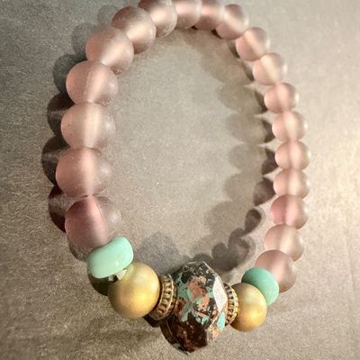handmade beaded stretch bracelet featuring frosted mauve beads and a distinctive patterned focal stone.