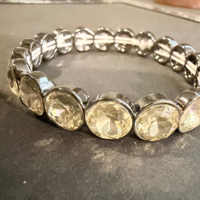 stretch bracelet featuring large, faceted yellow or amber-colored oval crystal gems type set in a dark metal tone.