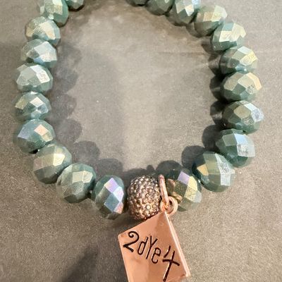 beaded stretch bracelet featuring faceted, blue-green or sage-colored glass or crystal beads, accented with a rose gold-toned pave bead...