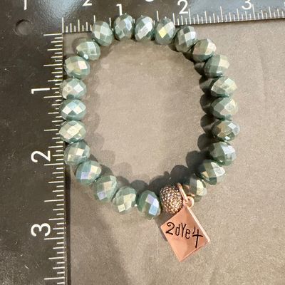 beaded stretch bracelet featuring faceted, blue-green or sage-colored glass or crystal beads, accented with a rose gold-toned pave bead...