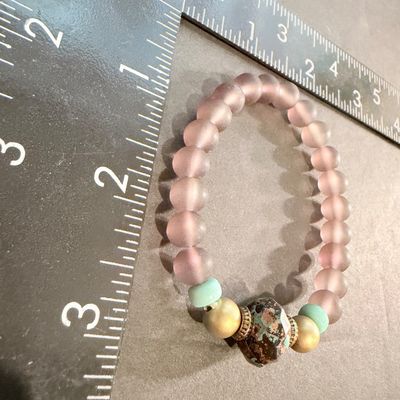 handmade beaded stretch bracelet featuring frosted mauve beads and a distinctive patterned focal stone.