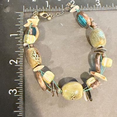 Premier Designs Island Girl Bracelet, featuring a multi-strand design with green and blue ceramic or glass beads and shell accents