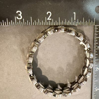 stretch bracelet featuring large, faceted yellow or amber-colored oval crystal gems type set in a dark metal tone.