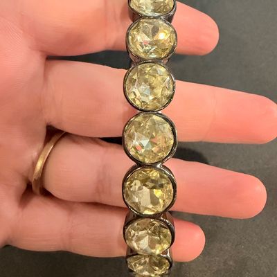 stretch bracelet featuring large, faceted yellow or amber-colored oval crystal gems type set in a dark metal tone.