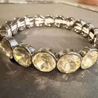 stretch bracelet featuring large, faceted yellow or amber-colored oval crystal gems type set in a dark metal tone.