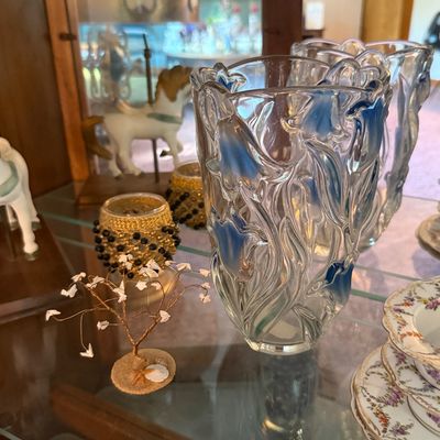 Art Nouveau style clear glass vase featuring embossed blue floral motifs, displayed alongside a miniature wire tree sculpture and beaded...