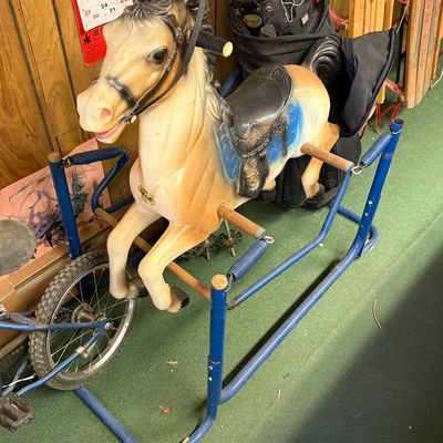 Vintage Wonder Horse spring rocking horse on a blue metal frame, showing some wear from age and use.