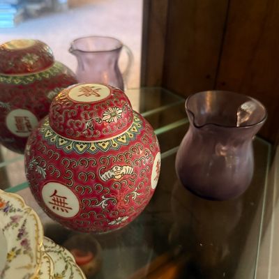 Chinese Mun Shou rose-ground ginger jar with lid, featuring longevity characters and floral scrollwork, displayed alongside small purple...
