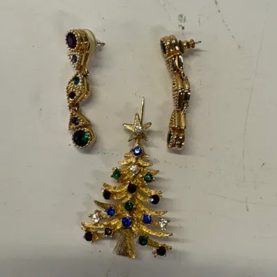 Vintage gold-tone Christmas tree brooch and matching dangle earrings set, adorned with multi-colored rhinestones.