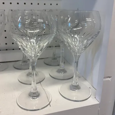 Set of crystal wine goblets featuring a cut glass leaf pattern on the lower bowl and a faceted stem.